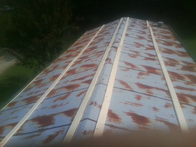 Rusted metal roof panels with new wood purlins before replacement — Storm Damage Roof Repair in Berwyn by Roofing Brothers